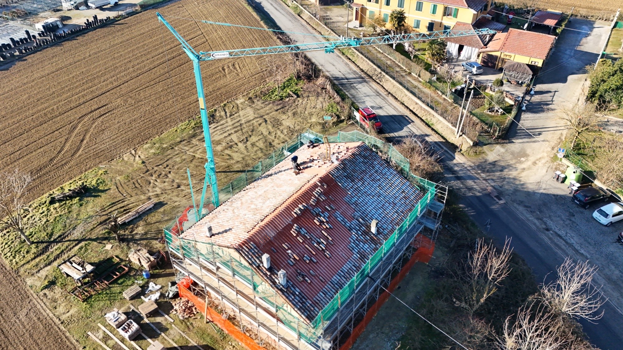 Tetto in rifacimento visto dall'alto, con la gru di cantiere a fianco